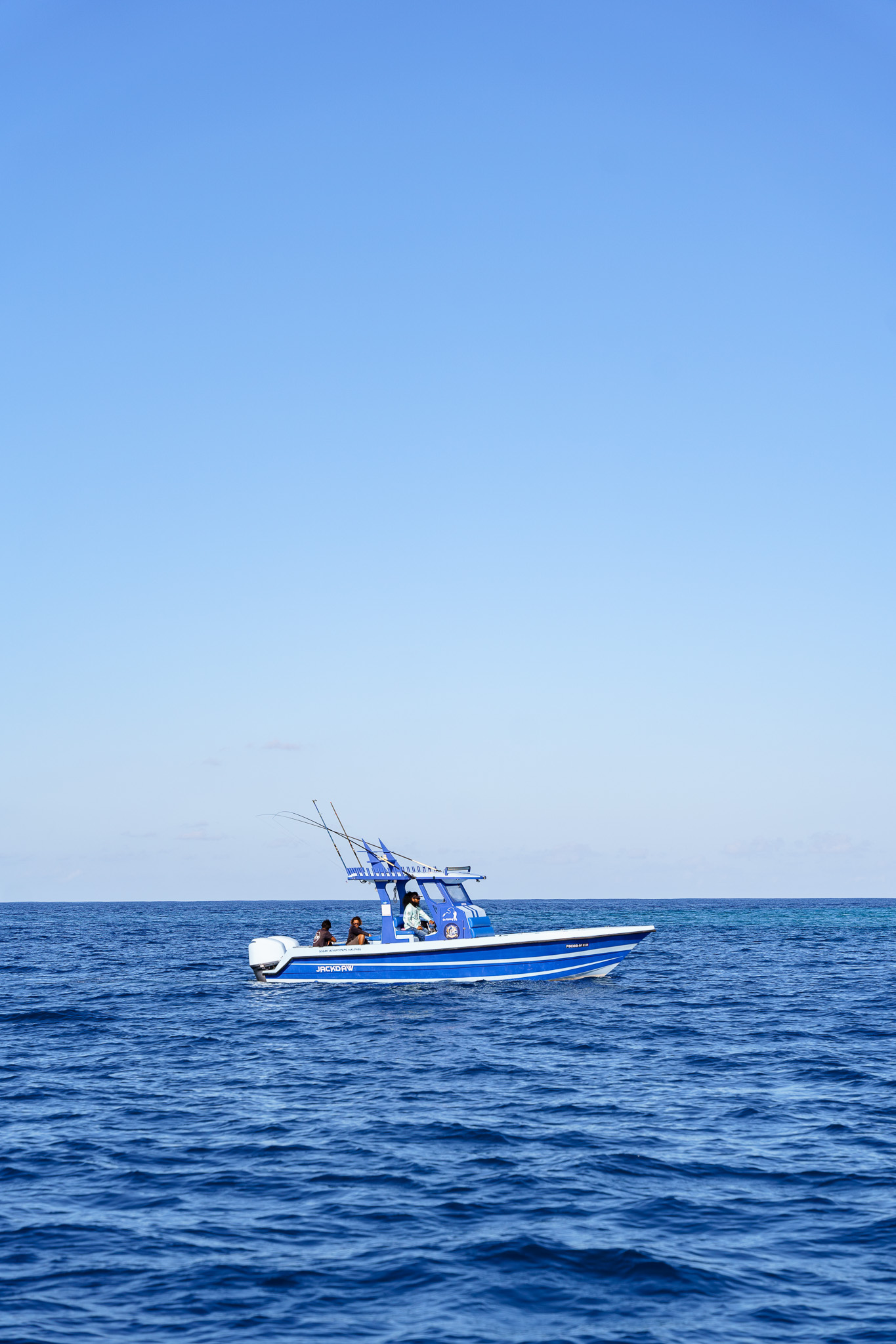 Center console fishing boat with crew on open ocean