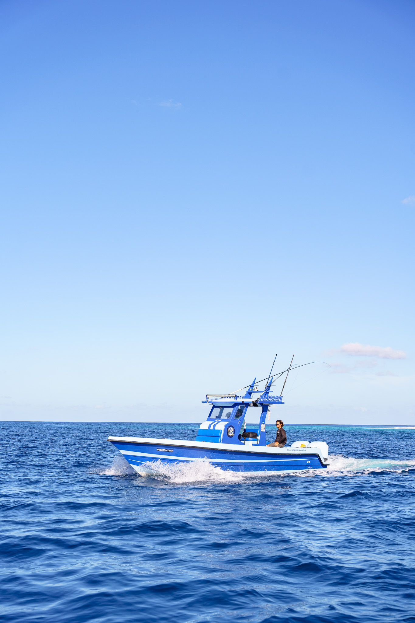 Sportfishing boat with outriggers running at speed